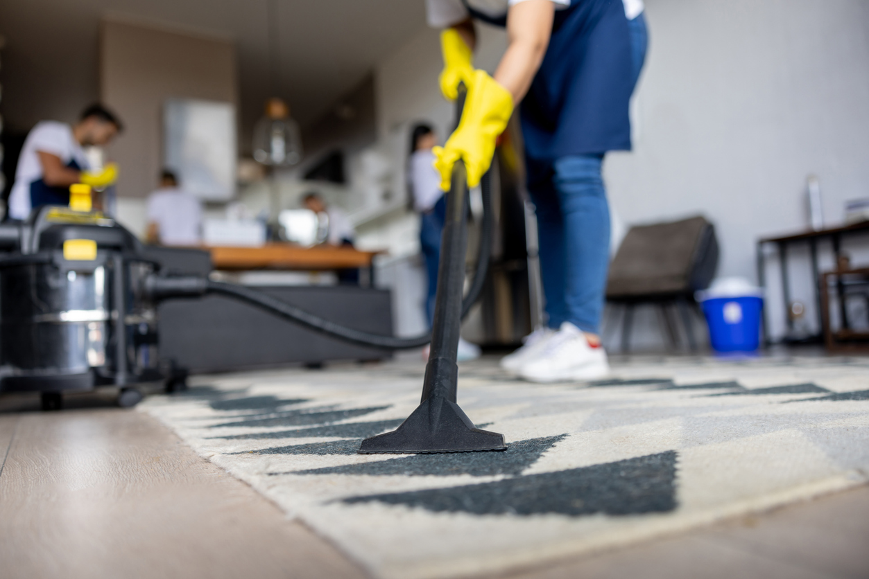 Professional cleaner vacuuming a carpet Biohazard cleaning team in Ottawa deep cleaning carpet with professional equipment in a residential home.