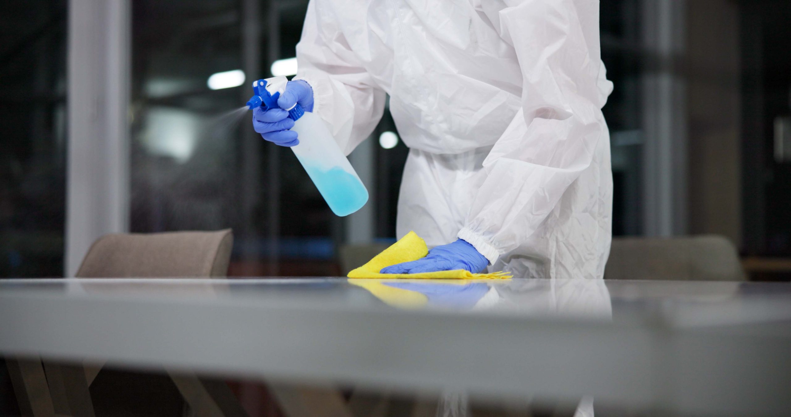Crime Scene Cleaners in Ottawa carry a spray bottle, and cleaning supplies in a home.
